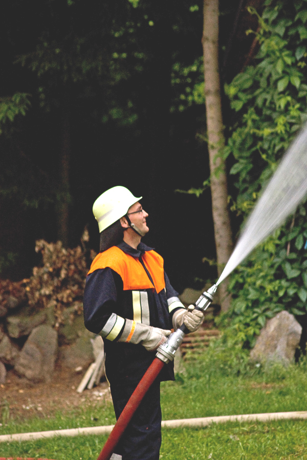 Feuerwehrmann der FFW Katzbach im Einsatz mit dem Löschschlauch