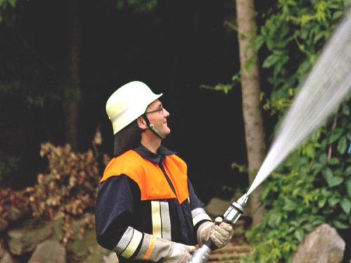 Feuerwehrmann der FFW Katzbach im Einsatz mit dem Löschschlauch